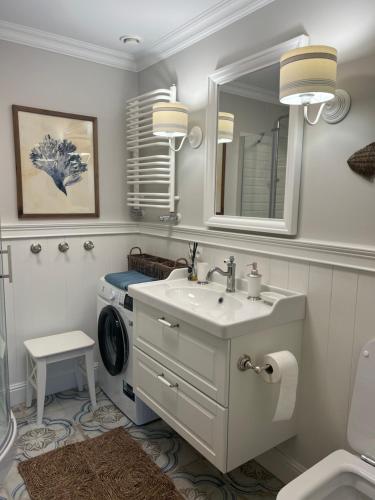 een badkamer met een wastafel en een wasmachine bij Morski Apartament Hampton w Playa Baltis in Międzyzdroje