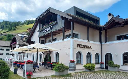 a large building with tables and chairs in front of it at Villa Sella in Selva di Val Gardena