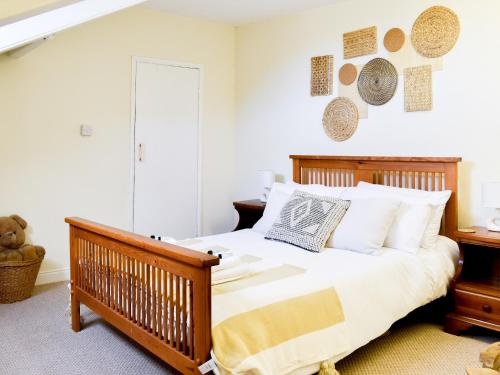 a bedroom with a wooden bed with white pillows at Ivy Cottage in Newchurch