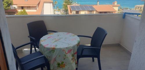 a table with chairs and a table cloth on a balcony at Eolie House in Tropea