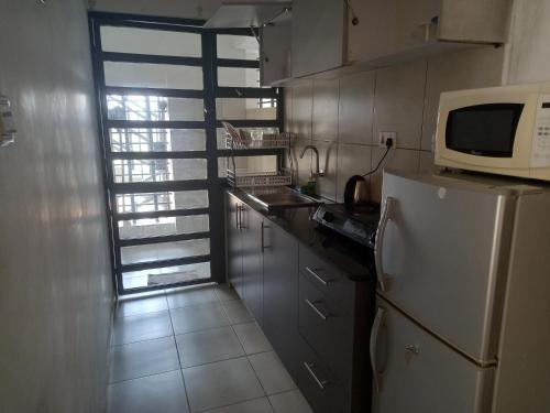 a kitchen with a white refrigerator and a microwave at Oasis comfort in Nairobi