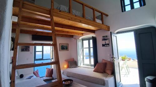 Habitación con cama elevada y vistas al océano. en Elias Cave House 270o Caldera View Oia, en Oia