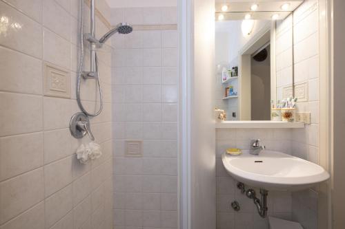 een witte badkamer met een wastafel en een douche bij La casa di Carmela - Amalfi Coast in Atrani
