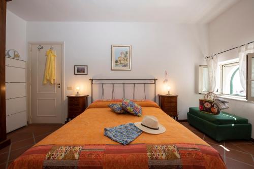 een slaapkamer met een bed met een hoed erop bij La casa di Carmela - Amalfi Coast in Atrani