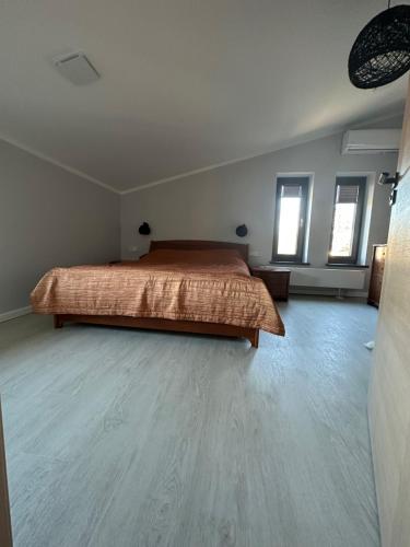 1 dormitorio con 1 cama y suelo de madera en Atpuutas māja pie Jūras-Riņķi, en Saulkrasti