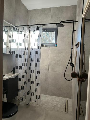 ein Bad mit einem Duschvorhang und einem Waschbecken in der Unterkunft Atpuutas māja pie Jūras-Riņķi in Saulkrasti