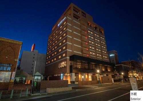 un edificio alto en una calle de la ciudad por la noche en La Vista Hakodate Bay Annex, en Hakodate