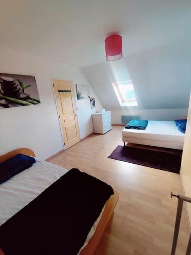 Cette petite chambre comprend 2 lits et une porte. dans l'établissement Maison a 400 m de la mer, à Saint-Germain-sur-Ay