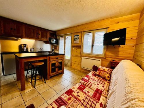 un salon avec un canapé et une cuisine dans l'établissement Appartement au pied des pistes, à Combloux