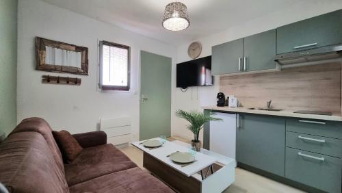 un soggiorno con divano e cucina di Chez K&D Studio Nature avec piscine St Raphaël a Saint-Raphaël