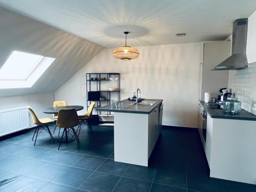 a kitchen with a sink and a table with chairs at ZEN op Vakantie - Zen aan De Gavers in Onkerzele