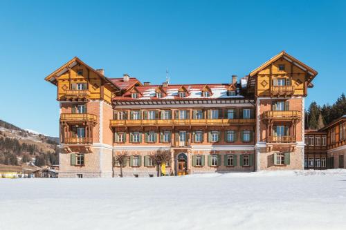 a large building with snow in front of it at Guesthouse - Cultural Center Gustav Mahler in Dobbiaco