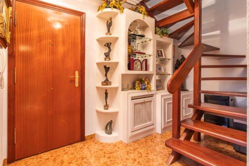a room with a staircase with shelves and a door at Rincón de Cantabria 1 in Santoña