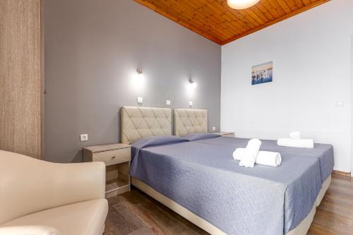 a bedroom with a bed and a couch at Oasis Hotel in Perama