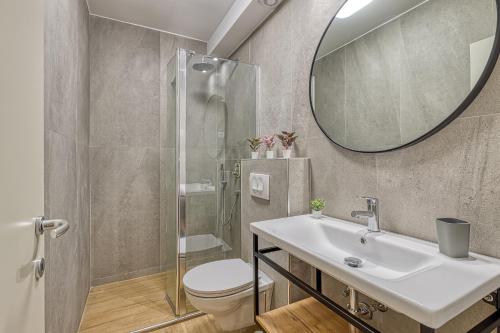 uma casa de banho com um lavatório, um WC e um espelho. em Villa Ladavac B&B em Rovinj