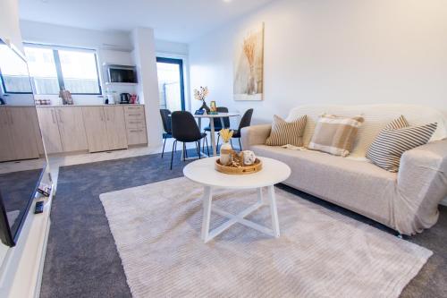 uma sala de estar com um sofá e uma mesa em Stylish 2-Bedroom Haven Next to Hagley Park em Christchurch