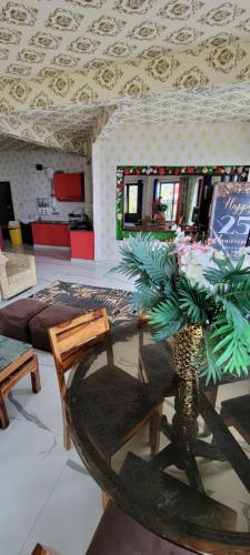 a living room with a table and a palm tree at Casa Arhan 2-3-4-7-12 BHK Luxury Penthouse in Mussoorie