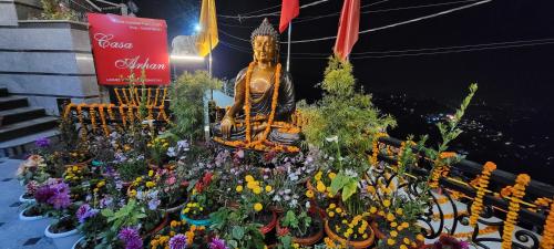 a bunch of flowers in front of a statue at Casa Arhan 2-3-4-7-12 BHK Luxury Penthouse in Mussoorie