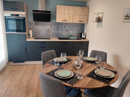 einen Esstisch mit Stühlen und eine Küche in der Unterkunft Kleine Auszeit - 2-Zimmer Ferienwohnung in Spiez