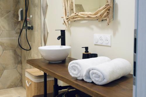 La salle de bains est pourvue d'un lavabo et de serviettes sur une table. dans l'établissement Au p'tit bonheur, à Rothbach
