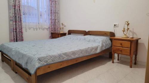 1 dormitorio con cama de madera y mesita de noche en Villa Lenia, en Torrevieja