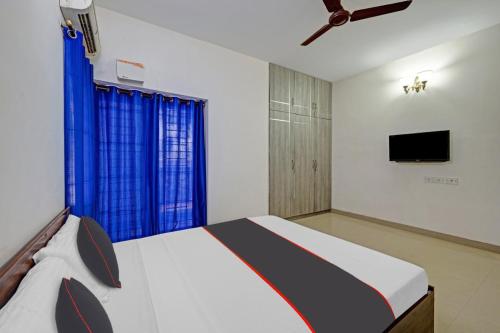 a bedroom with a bed and a flat screen tv at Chennai Airport Guest House in Chennai