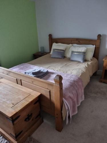 a bedroom with a large wooden bed with two pillows at Cameron House - spacious B listed building, near Falkland, Central East Scotland in Auchtermuchty
