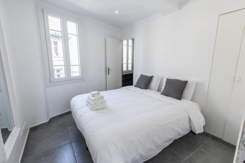 - une chambre blanche avec un grand lit blanc et 2 fenêtres dans l'établissement Cannes Croisette Rue Meynadier Palais 1 mn Modern 1 BR by Olam Properties, à Cannes