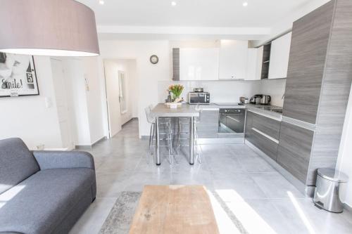 un salon avec un canapé et une cuisine dans l'établissement Cannes Croisette Rue Meynadier Palais 1 mn Modern 1 BR by Olam Properties, à Cannes