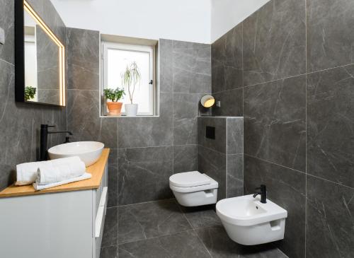 a bathroom with a white toilet and a sink at Designer Two-Bedroom Apartment in Split