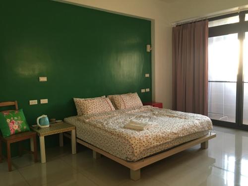 宜蘭市にある東津左岸民宿の緑の壁のベッドルーム1室