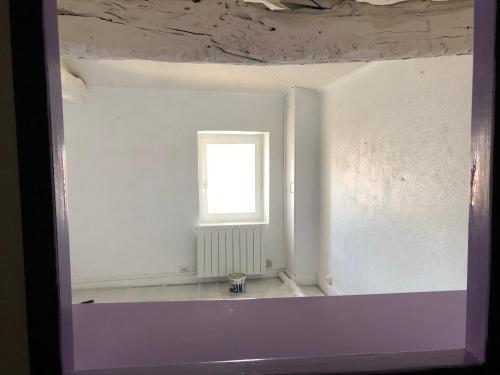 an empty room with a window and a white wall at Le Nid du bois d'Oingt in Le Bois-dʼOingt