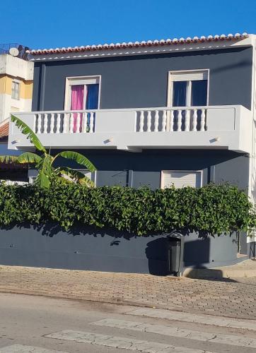 a blue building with a white balcony and plants at "A Casa dos Avôs" Suites & Breakfast in Lagos