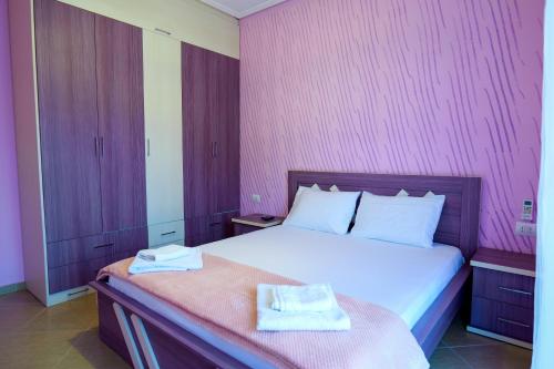 a bedroom with a bed with two towels on it at Brothers LR in Sarandë