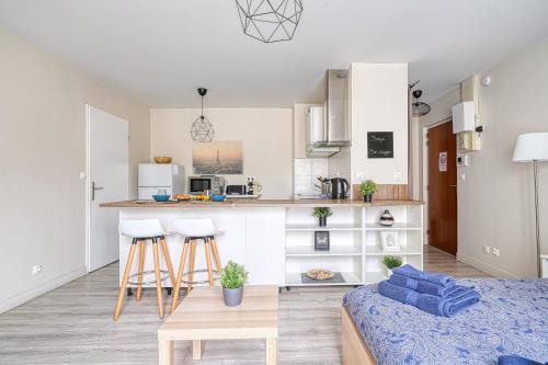 Logement Noah في Courcouronnes: غرفة معيشة ومطبخ مع أريكة وطاولة