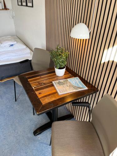 stół z doniczką i łóżko w pokoju w obiekcie Danhostel Rønde w mieście Rønde