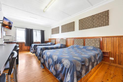 una habitación de hotel con 3 camas en una habitación en Tamworth Lodge Motel en Tamworth
