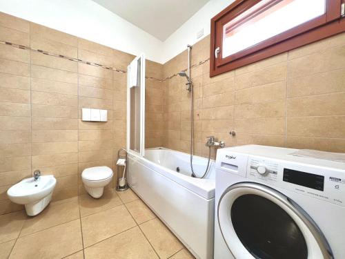 een badkamer met wasmachine en toilet bij Apartment GardaBeBo in Nago-Torbole