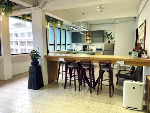 a kitchen with a bar and stools in a room at Leisure Lodge in Kuala Terengganu