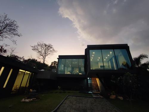 a black house with glass windows in a yard at Villa Obsidian, sea view and walk to Choeng Mon beach in Choeng Mon Beach