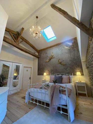 a bedroom with a bed with a painting on the wall at Figtrees in Margueron