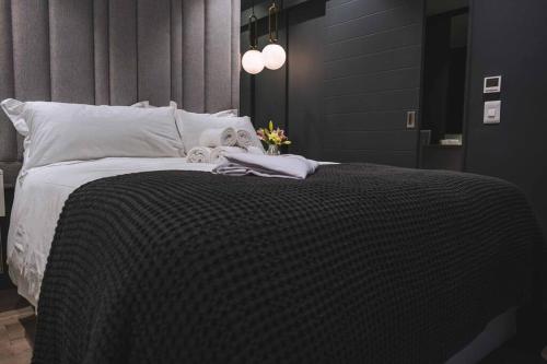 ein Bett mit einer schwarz-weißen Decke drauf in der Unterkunft Stylish one bedroom with stunning Lion's Head & Table Mountain views in Kapstadt