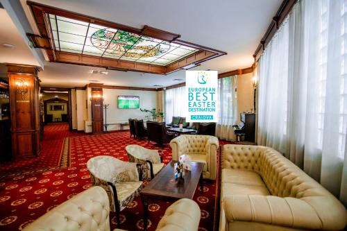 a lobby with couches and a table and a sign at Hotel Golden House in Craiova