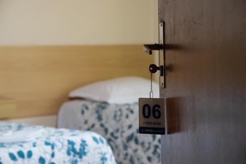 a door with a sign on it in a bedroom at HOTEL TROPICAL in Curitiba