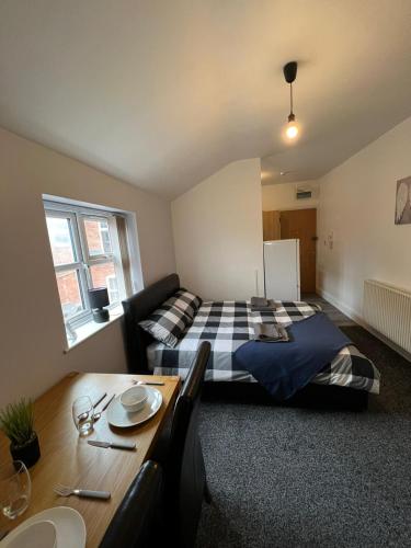 - une chambre avec un lit et une table à manger dans l'établissement No.9 Cosy Private Studio in Moseley, Birmingham, à Birmingham