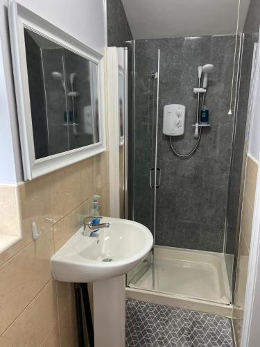 La salle de bains est pourvue d'un lavabo et d'une douche. dans l'établissement No.9 Cosy Private Studio in Moseley, Birmingham, à Birmingham