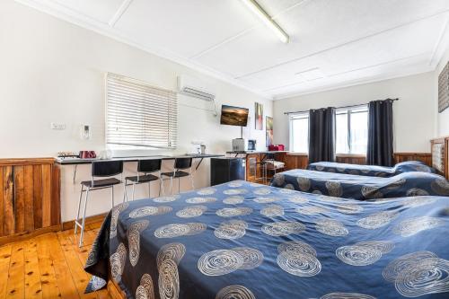 a bedroom with two beds and a kitchen at Tamworth Lodge Motel in Tamworth