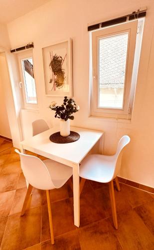 a white table and chairs in a room with a window at Künstler Ferienwohnung am Weilburger Schloss, Marktplatz 9 in Weilburg