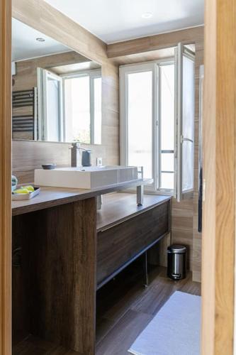 une salle de bain avec un lavabo et un grand miroir dans l'établissement Appartement proche DisneyLand et Paris, à Bussy-Saint-Georges