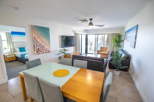 a dining room and living room with a table and chairs at Pavillions on 1770 in Agnes Water